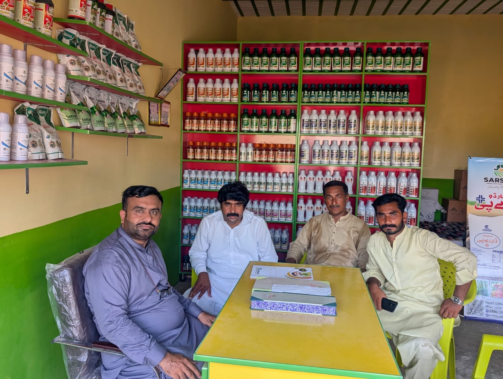 SARSBAZ team at agri shop with full product shelves
